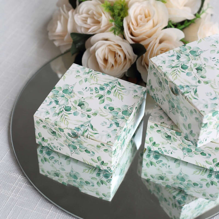 Decorative gift boxes with floral design on a mirrored surface.