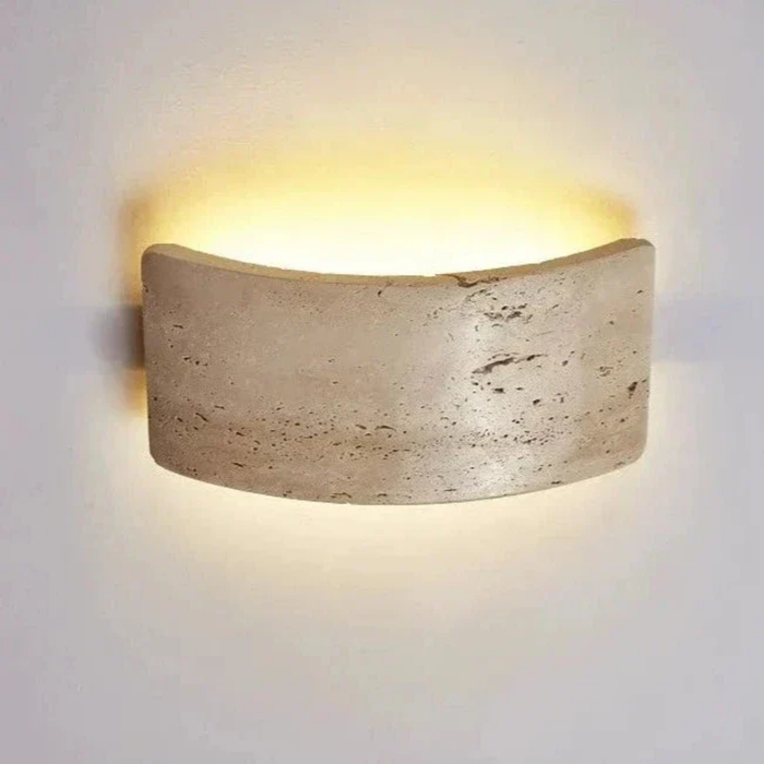 Close-up front view of Arclume Yellow Travertine Wall Light showing curved stone texture and light glow