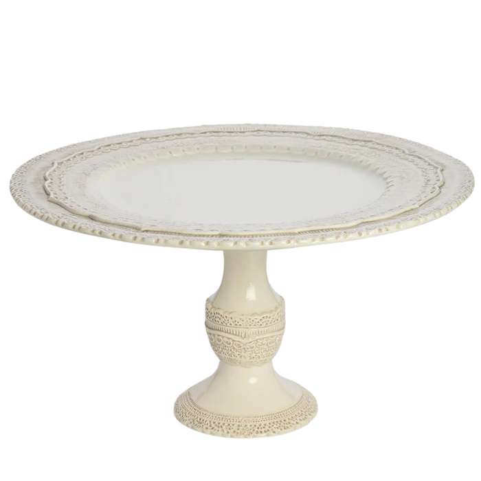 Decorative cake stand with intricate lace detailing on a white background