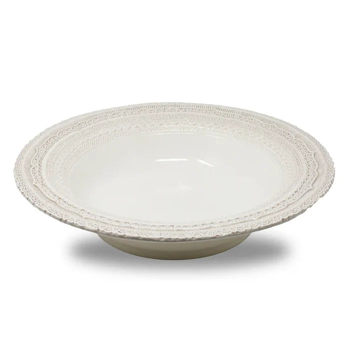 White ceramic bowl with decorative lace styled rim on a white background