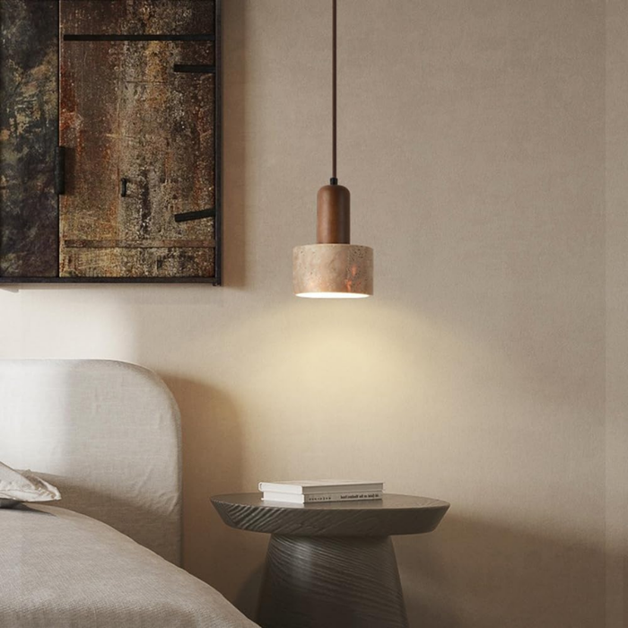 Two Aurelia Travertine Cylinder Pendant Lights flanking abstract wall art above a bed