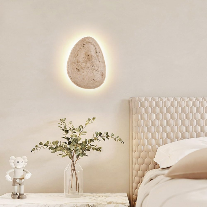 lifestyle three sconces clustered on a wall near a potted plant