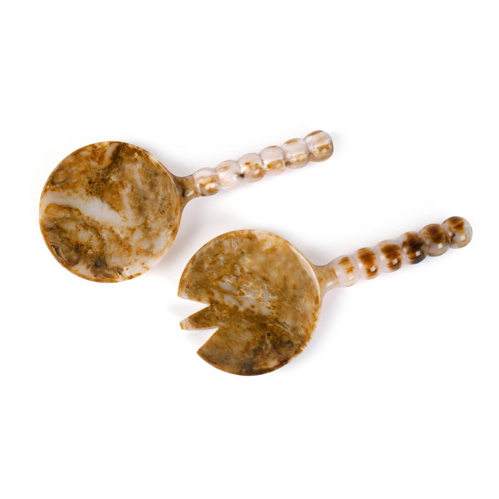 Two marbled stone spoons with beaded handles on a white background