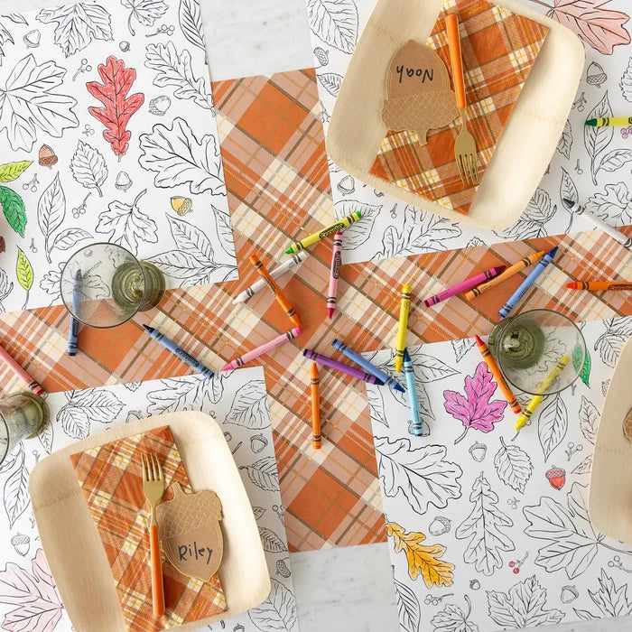 Coloring book pages with autumn-themed designs and crayons on a table.