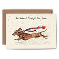 Greeting card with a dachshund illustration wearing a scarf, set against a snowy background.