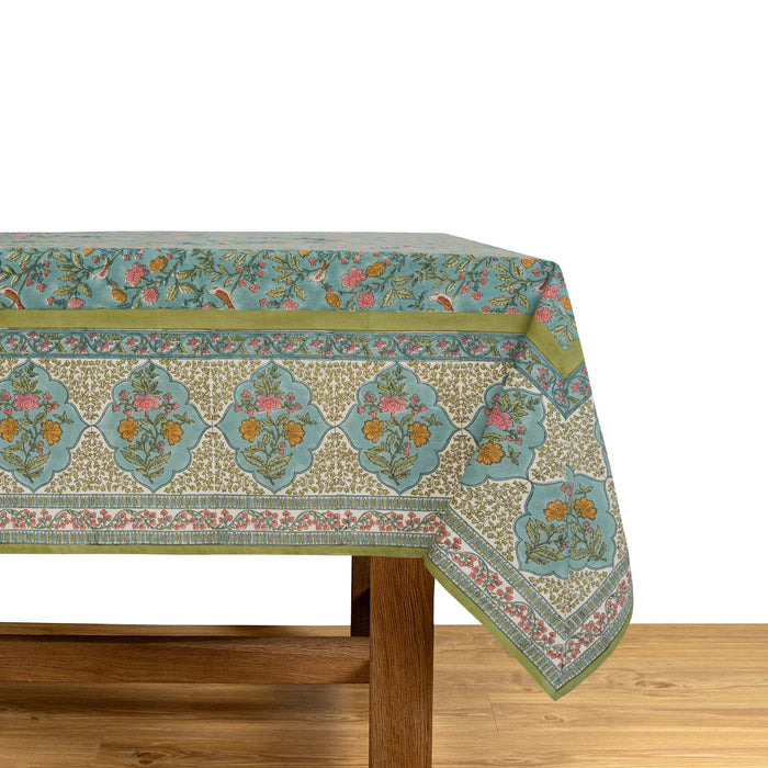 Floral patterned green and blue tablecloth on a wooden table