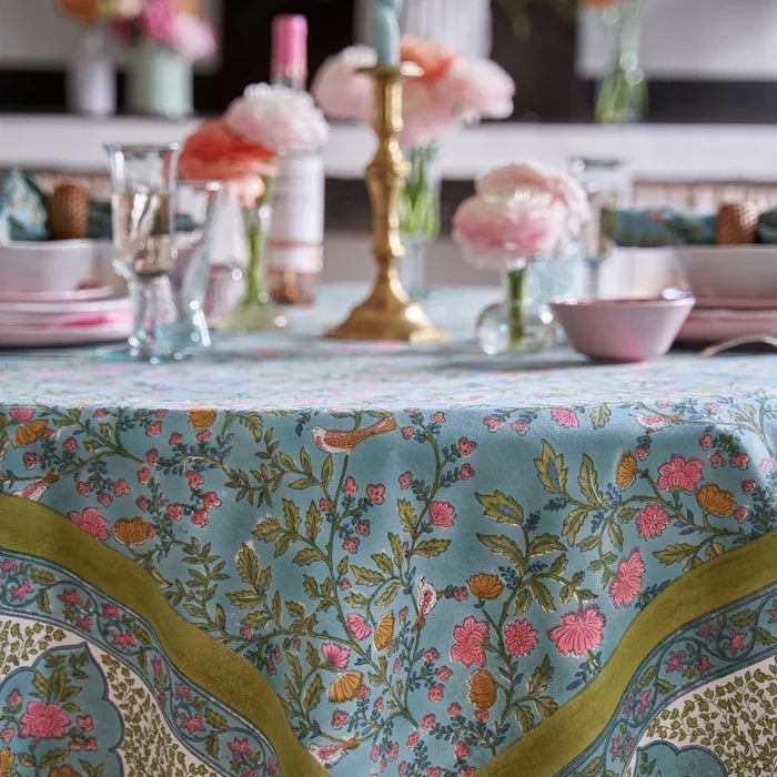 Decorative tablecloth with blue and green floral pattern on a table setting.