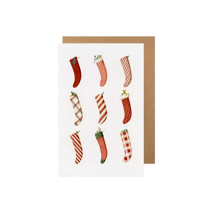 A Christmas-themed card with stockings and a brown craft paper envelope