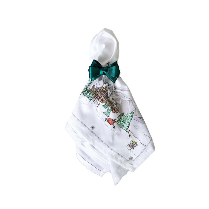 White napkin with a festive design and green bow