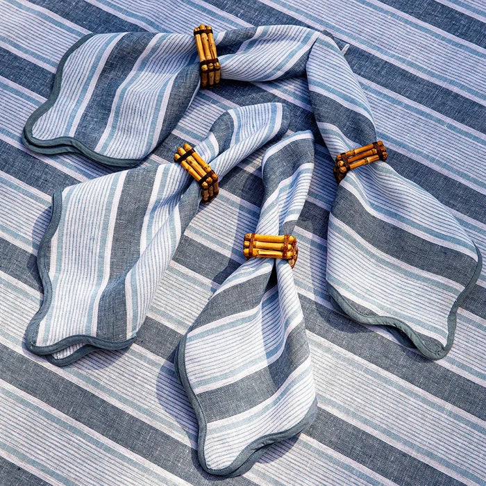 Blue and white striped napkins with bamboo napkin rings on a matching tablecloth