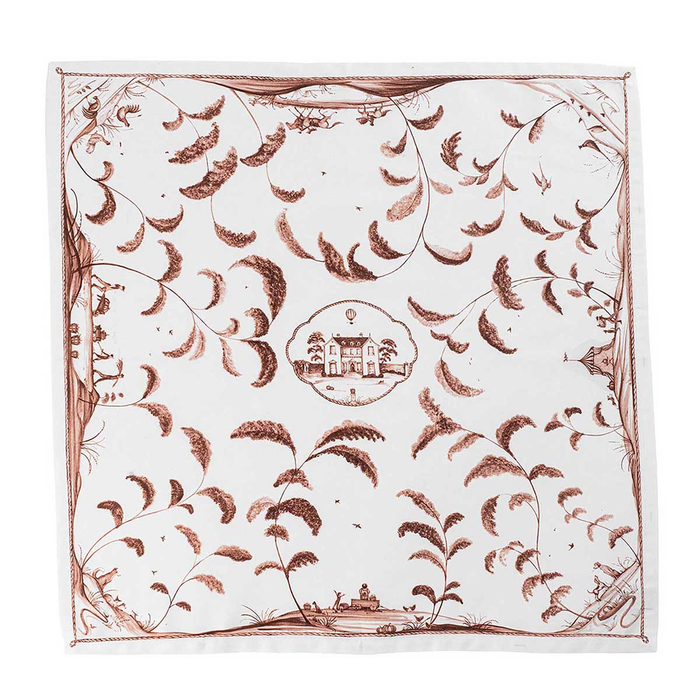 Decorative napkin with intricate brown patterns and central emblem of a country estate on a white background