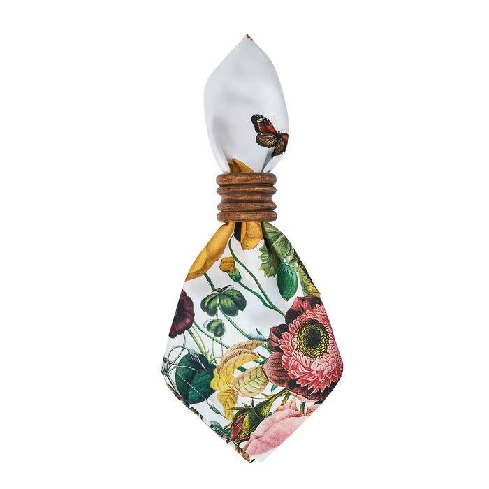 White floral patterned napkin tied with a wooden napkin ring