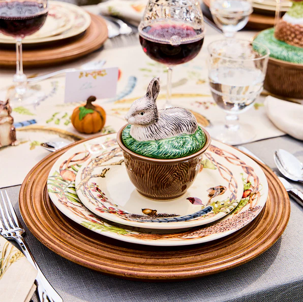 Decorative table setting with a fall rabbit-themed lidded bowl on a plate.
