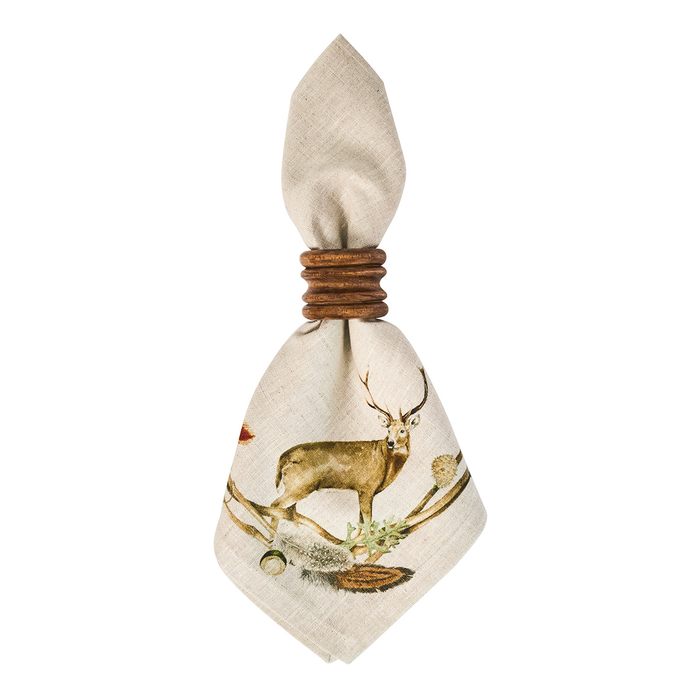 A beige linen napkin tied with a wooden napkin ring, featuring a printed illustration of a stag and feathers