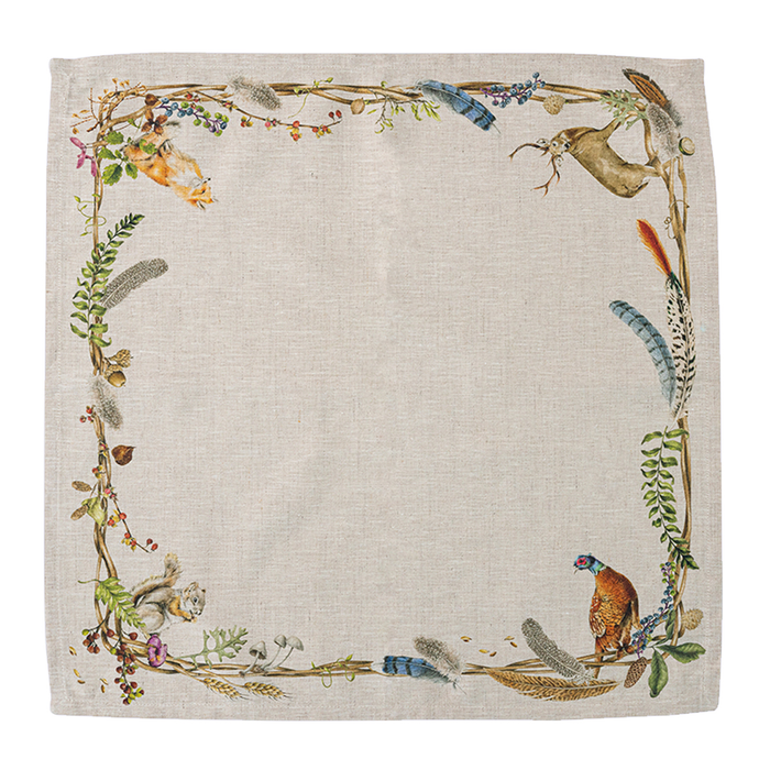 A square linen napkin, decorated with a botanical border of leaves, feathers, and small woodland animals including a hare, a pheasant, a bird, and a squirrel.