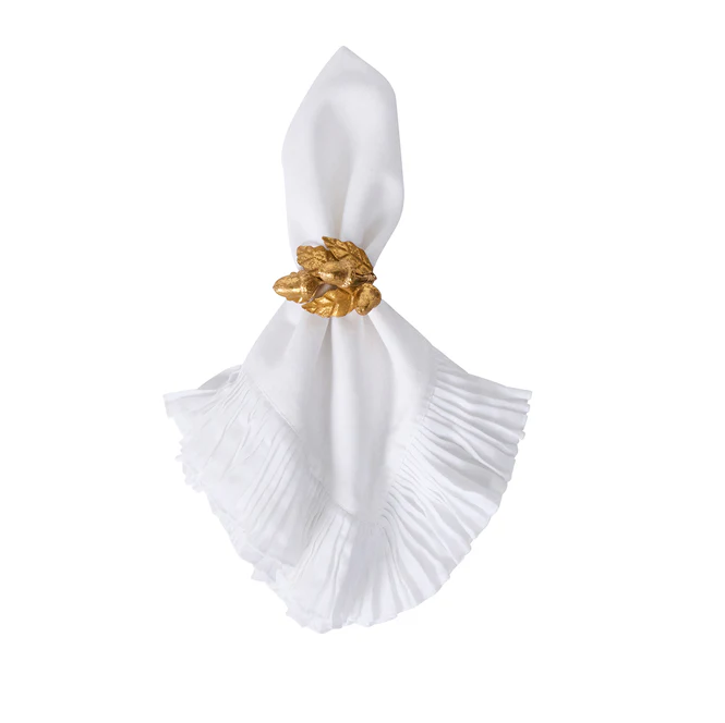 white napkin held by a gold acorn napkin ring