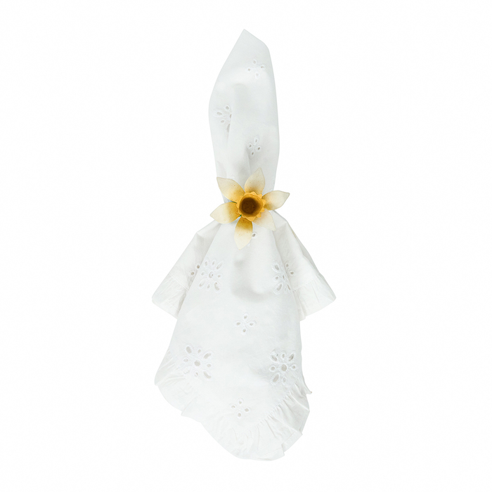 White napkin tied with a white and yellow daffodil napkin ring