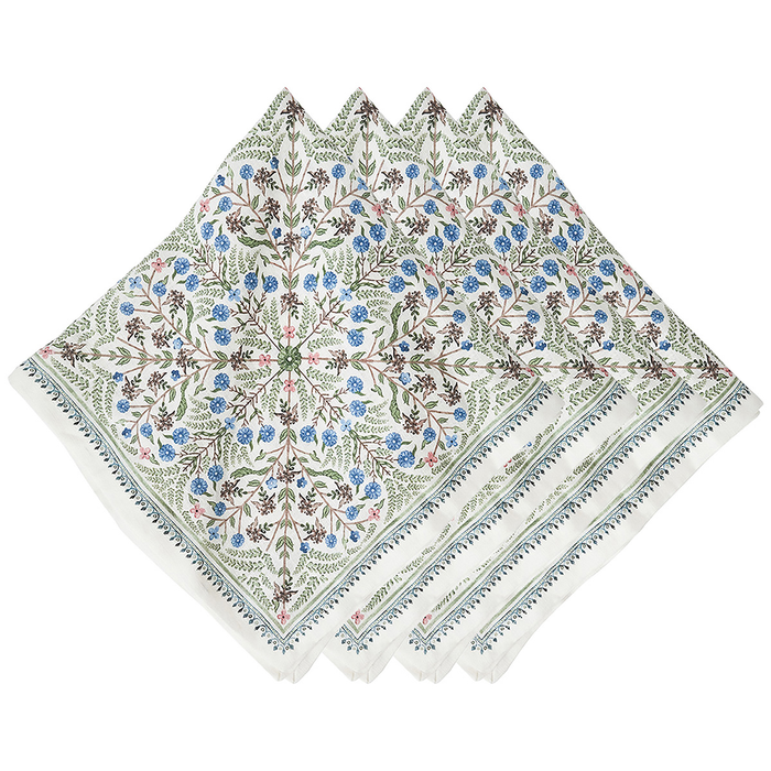 A stack of white napkins with an intricate botanical and floral pattern in shades of blue, green, and brown