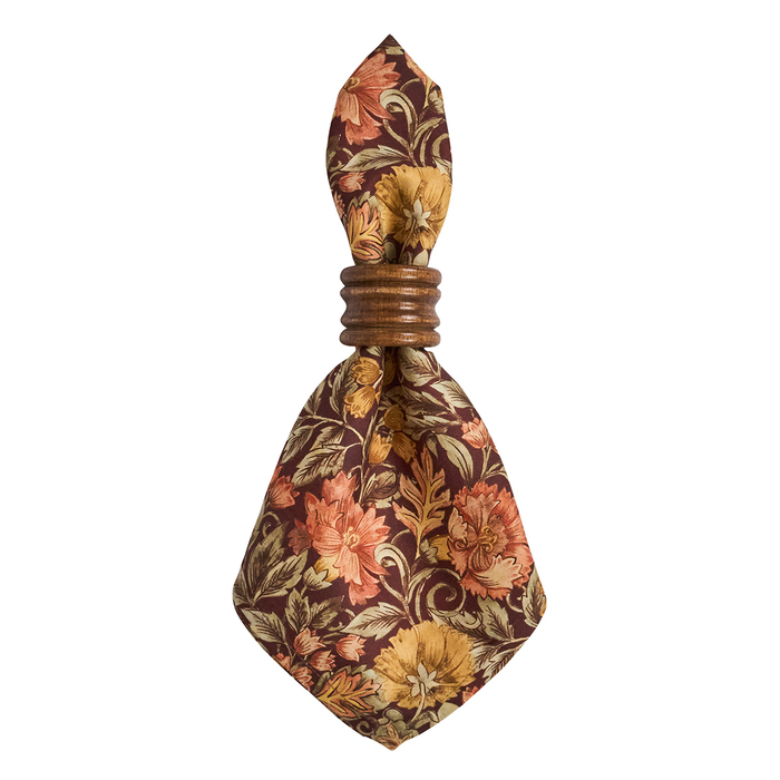An autumn floral patterned napkin with a wooden napkin ring