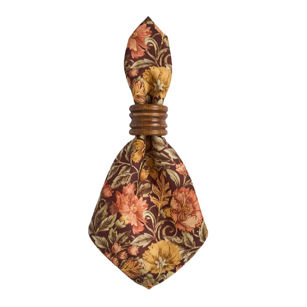 Willa amber floral patterned napkin in a Juliska Bilbao ring on a white background