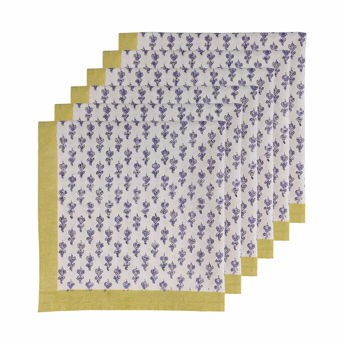 A set of five folded napkins with a white background, blue floral block print, and a mustard yellow border