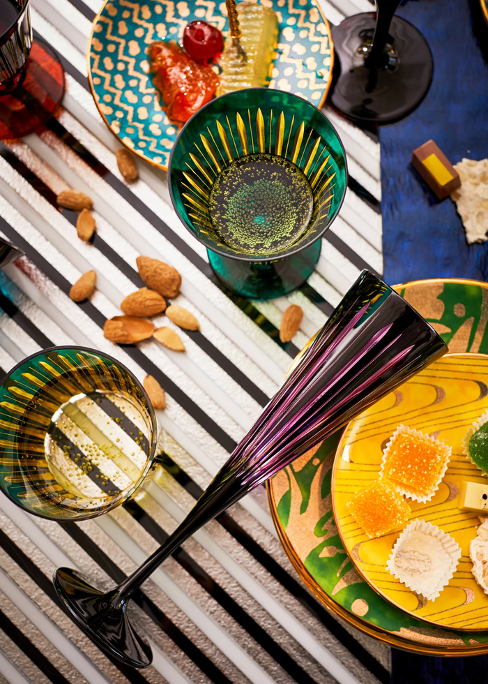 Colorful champagne flutes with garnishes on a striped tablecloth