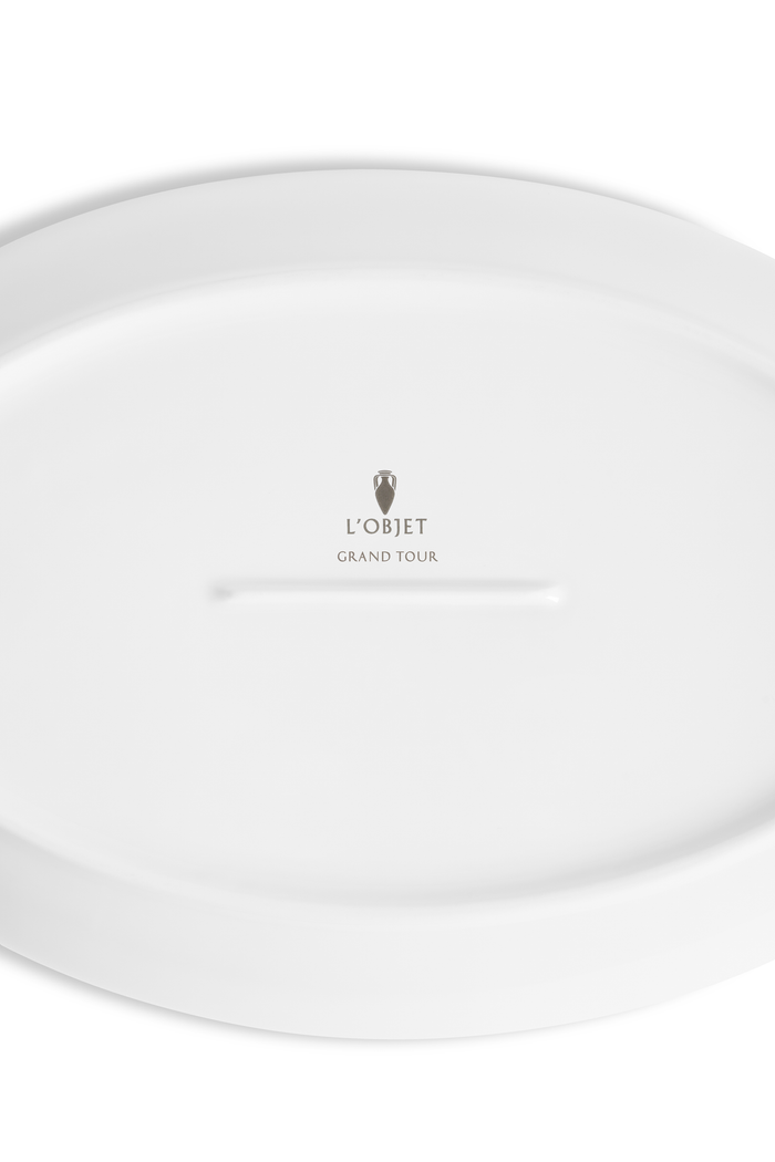 The bottom of a porcelain saucer with the L'Objet logo and "grand tour" imprinted