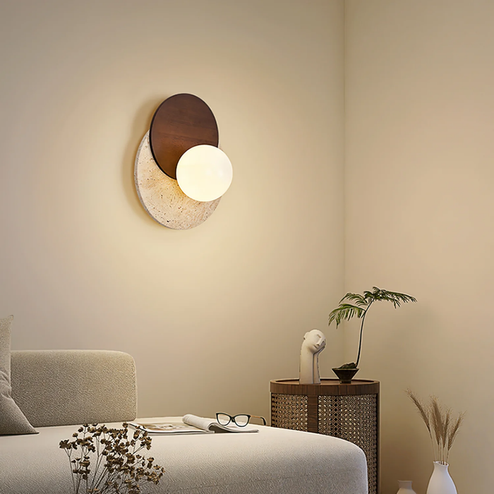 Lunara Travertine Stone & Wood Lunar Eclipse Wall Light installed in a bedroom corner beside a side table