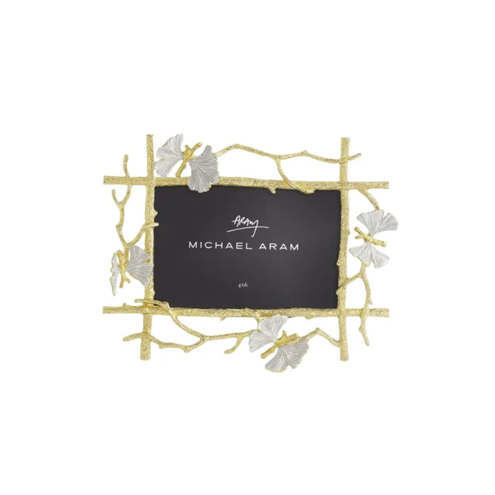 A gold-colored metal picture frame with a butterfly motif and white enamel accents, branded by Michael Aram.