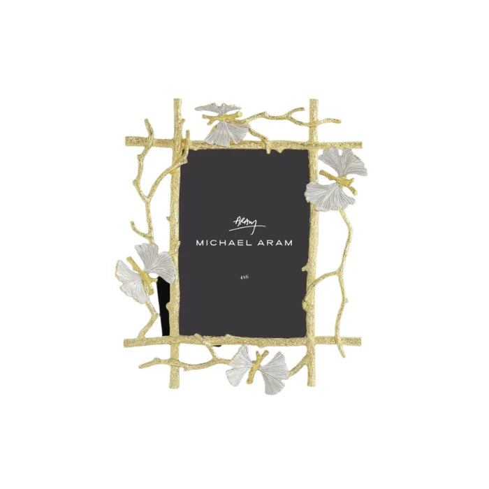 A photo frame gift with a sculptural twig and ginkgo gold and white decorative border