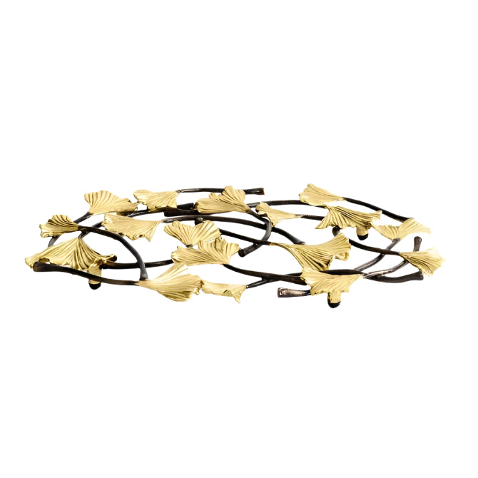 A black and gold metal trivet with a ginkgo leaf pattern.
