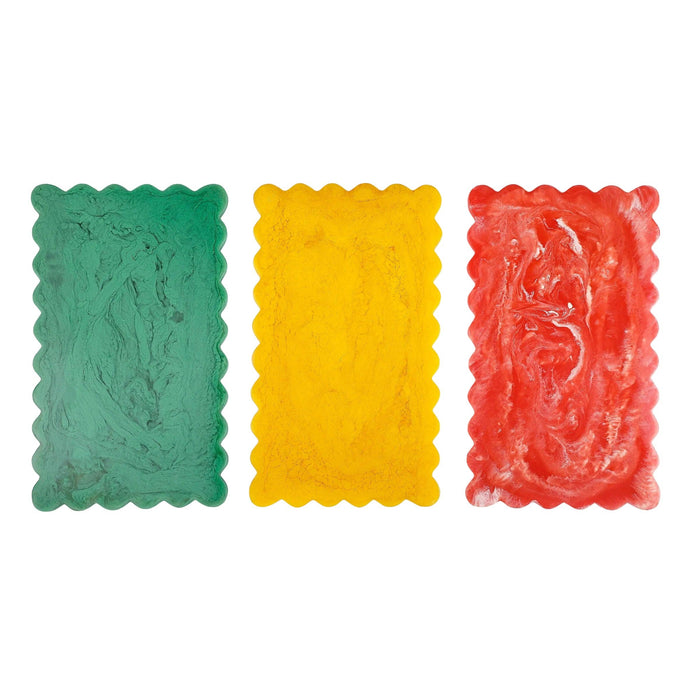 Three rectangular gummy candies in green, yellow, and red on a white background