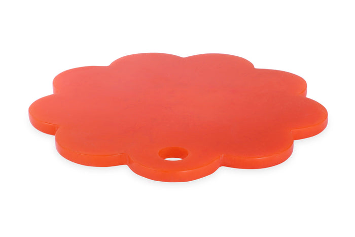 A bright orange, flower-shaped plastic trivet or coaster with a small hole in one of its petals, shown on a plain white background.