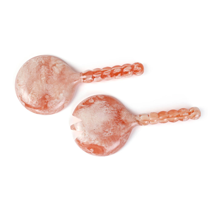 Two pink glass ladles on a white background