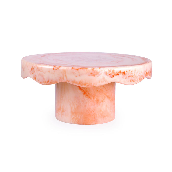 A round pedestal side table made of pink and white marbled stone, featuring a scalloped edge on the tabletop and a cylindrical base, shown on a plain white background.
