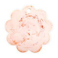 A scalloped flower-shaped tag or charm with a small hanging hole, featuring a light pink and white marbled pattern with scattered orange speckles, shown on a plain white background.