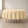 Beige round polyester tablecloth on a dining table.
