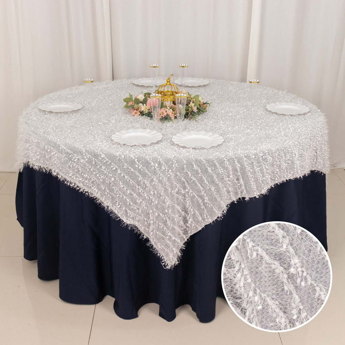 Elegant round table set with a white textured tablecloth and decorative centerpiece.