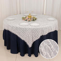 Elegant round table set with a white textured tablecloth and decorative centerpiece.
