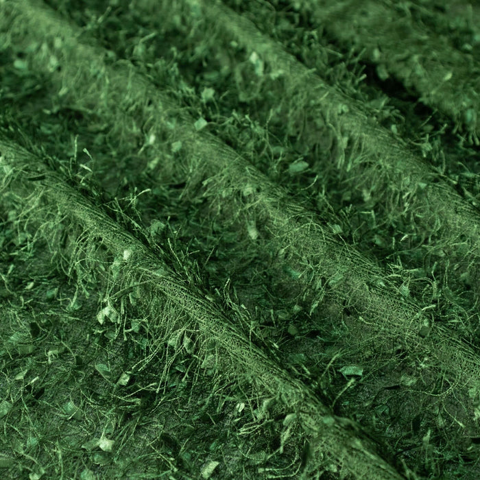 Close-up of textured green fabric with natural fibers.