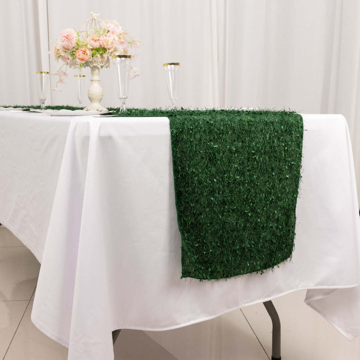 Green grass table runner on a white table with floral centerpiece.