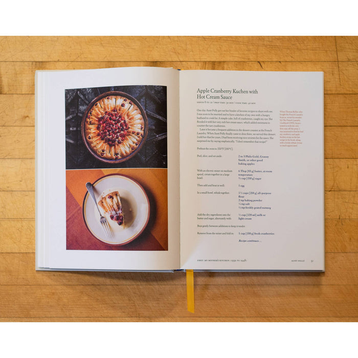 Open cookbook on a wooden surface with images of a dessert and text.