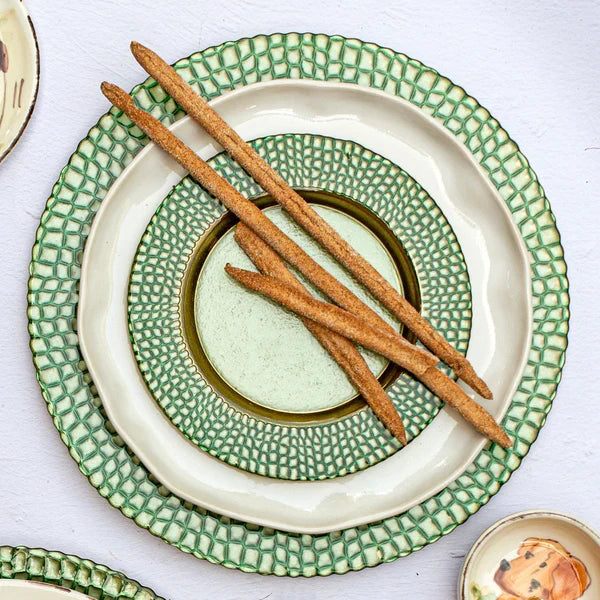 Green and white ceramic plates with breadsticks