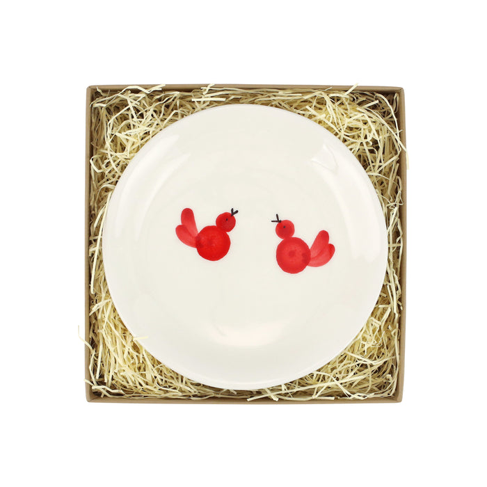White plate with two red birds painted on it