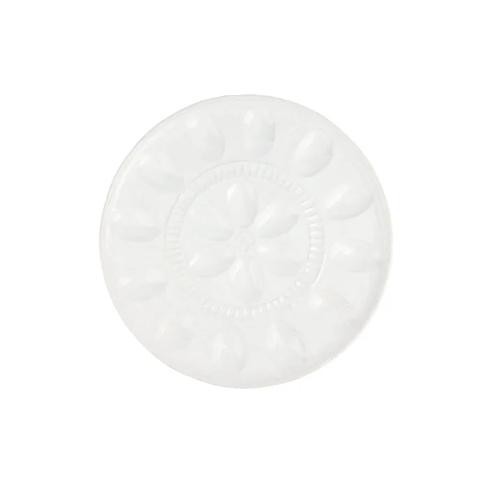 A round white ceramic plate with a raised floral pattern in the center and petal-like indentations around the rim, shown on a plain white background.