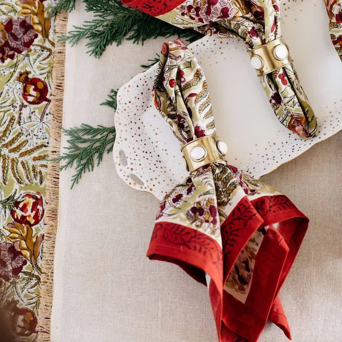 Decorative napkin with red and green floral pattern on a table setting